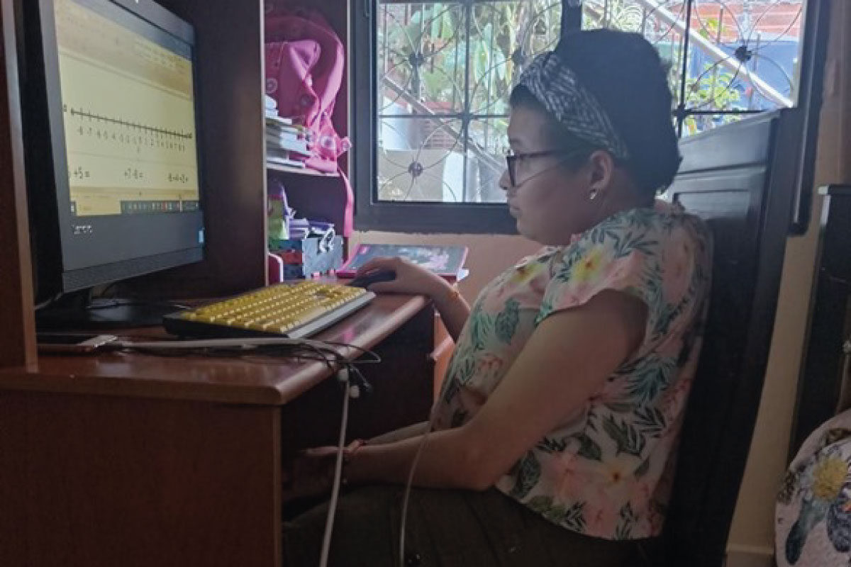 Estudiante del cibercolegio realizando sus actividades en el computador