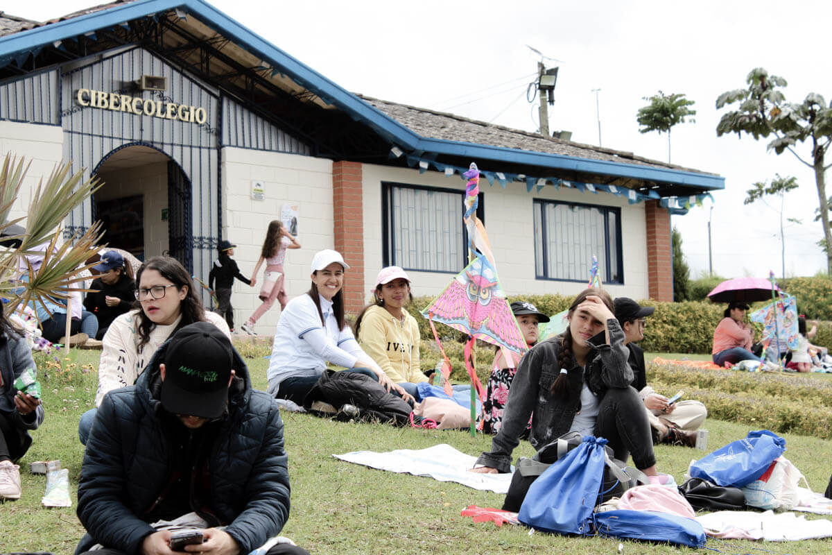 Familias disfrutando del festival de cometas en la zona verde del Cibercolegio UCN.