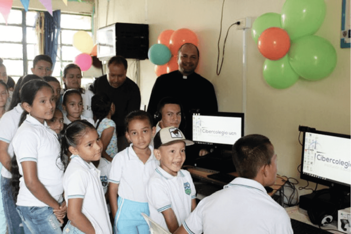 El rector del Cibercolegio Pbro. Eduin Salazar y el rector de la UCN Pbro. Diego Rendón, con grupo de niños y jóvenes en el nuevo centro aprende