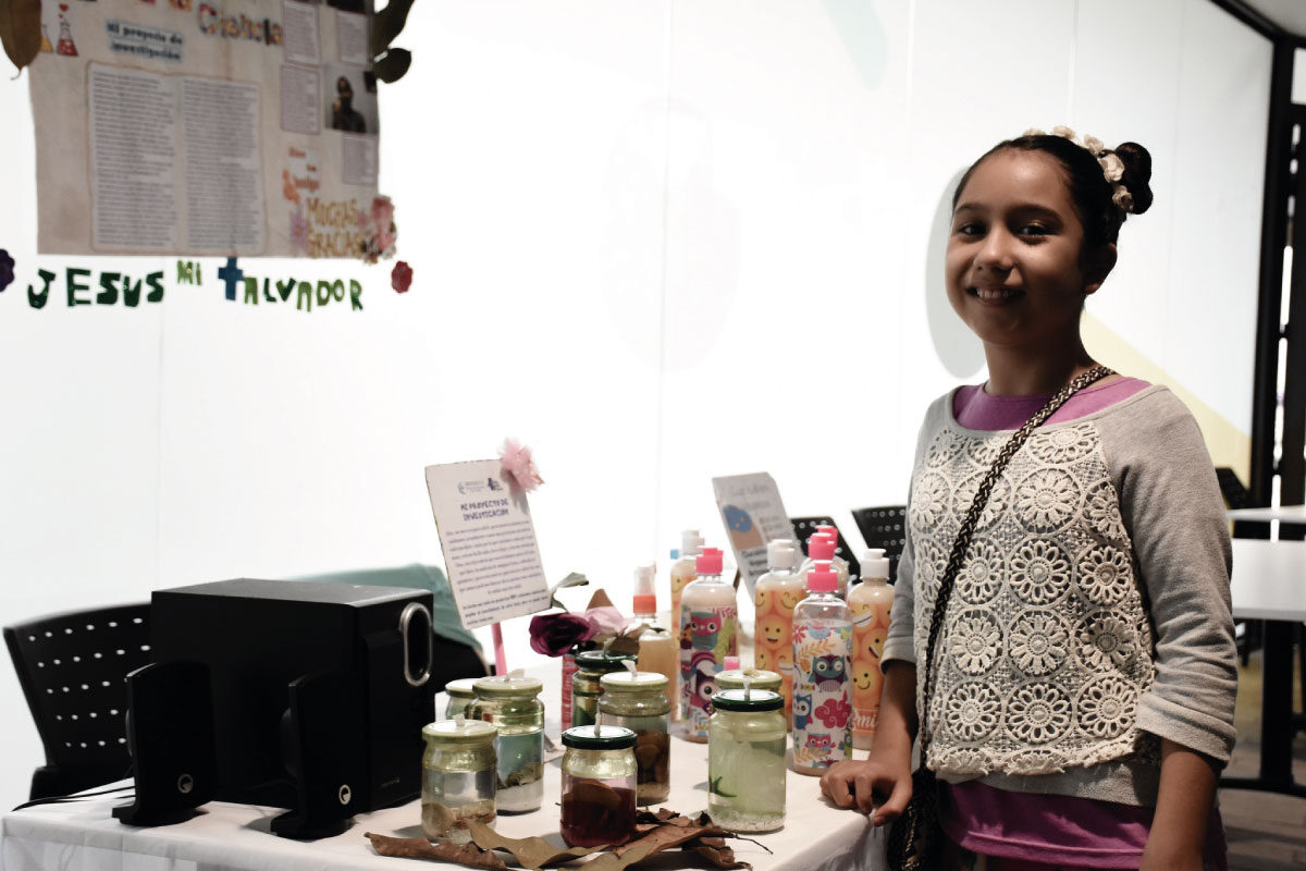 Imagen de alumna del Cibercolegio presentando su proyecto en la feria de ciencia