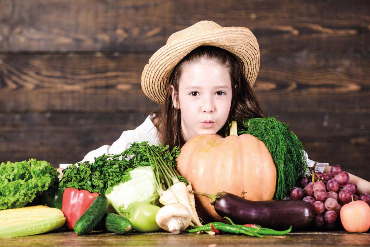 niña con frutos de cosecha