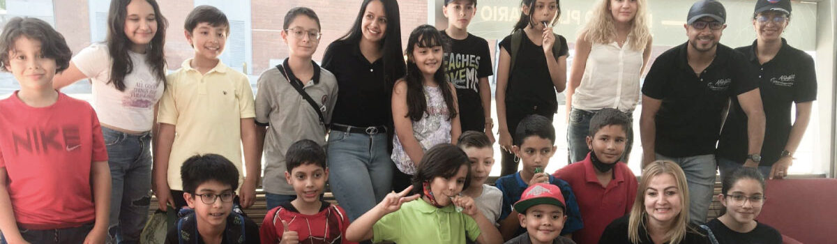 Fotografía de alumnos y docentes del Cibercolegio UCN visitando el planetario de Medellín