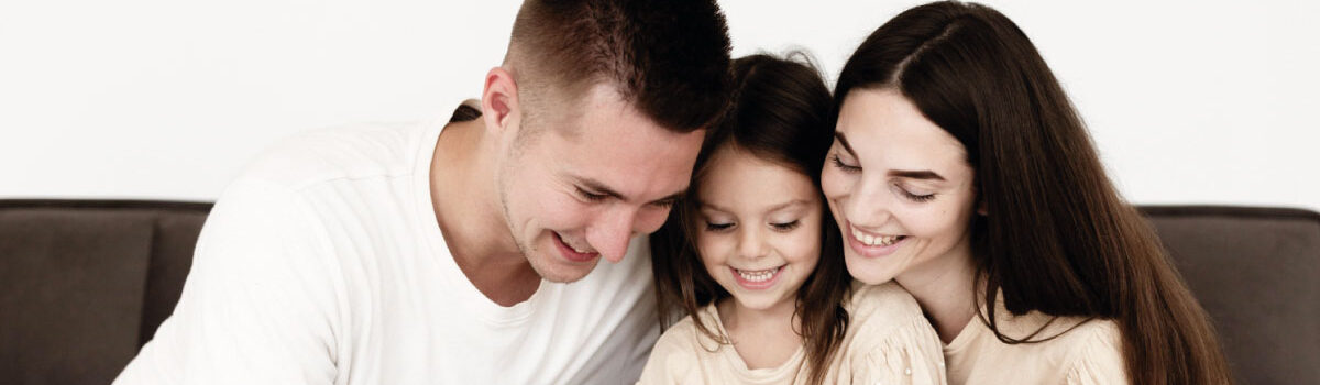 Familia conformada por el padre, la madre y una hija escribiendo su proyecto de vida