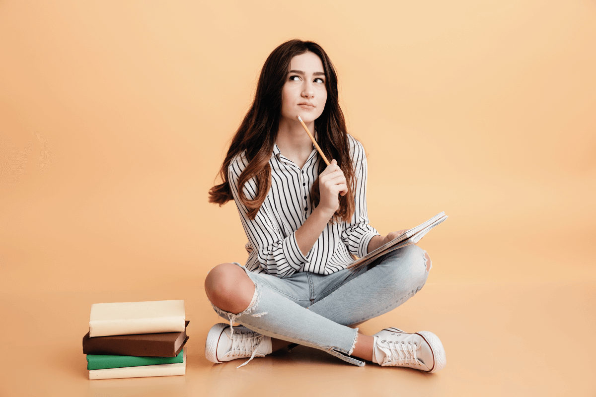 Jóven con libros y lápicero pensando como escribir